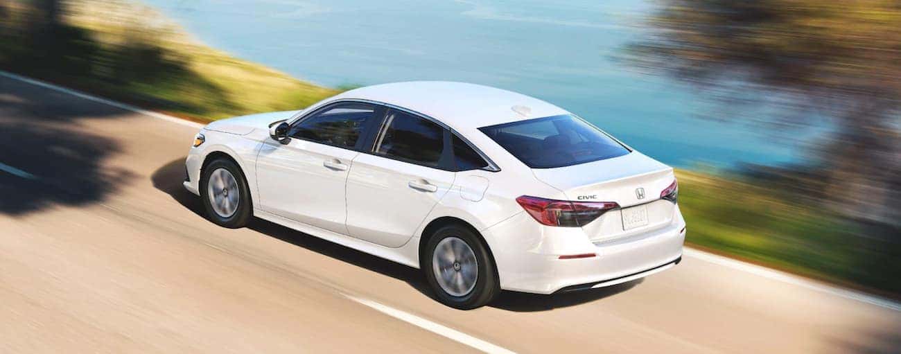 Rear of a white 2022 Honda Civic LX driving down a road.