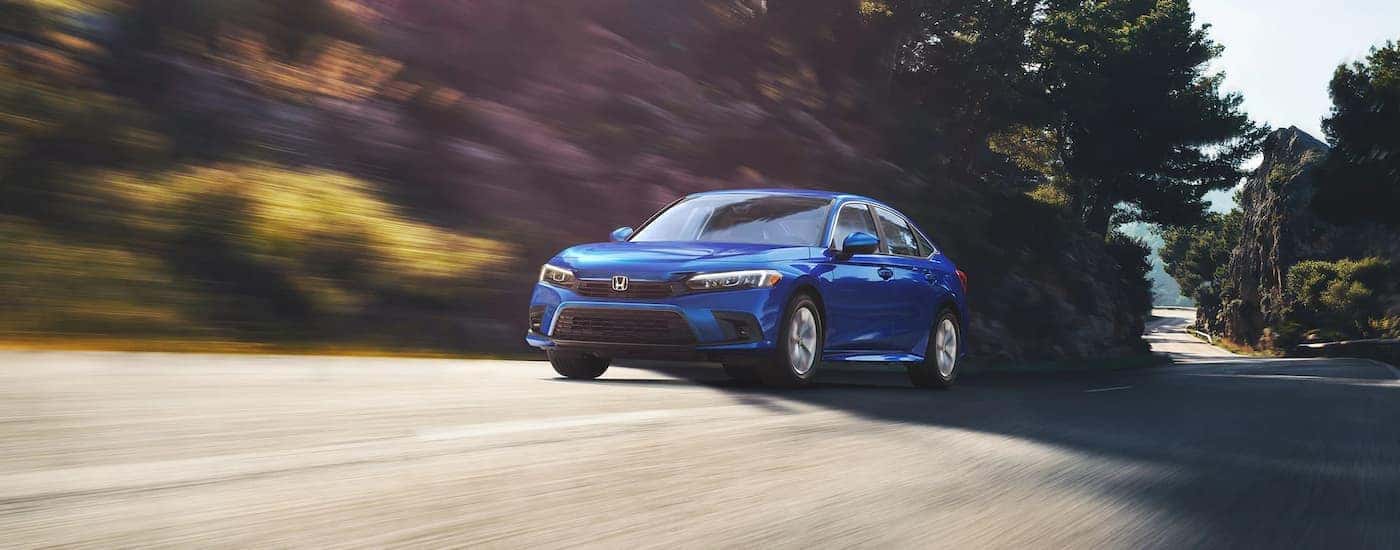 A blue used 2022 Honda Civic LX for sale near Coventry driving down a street