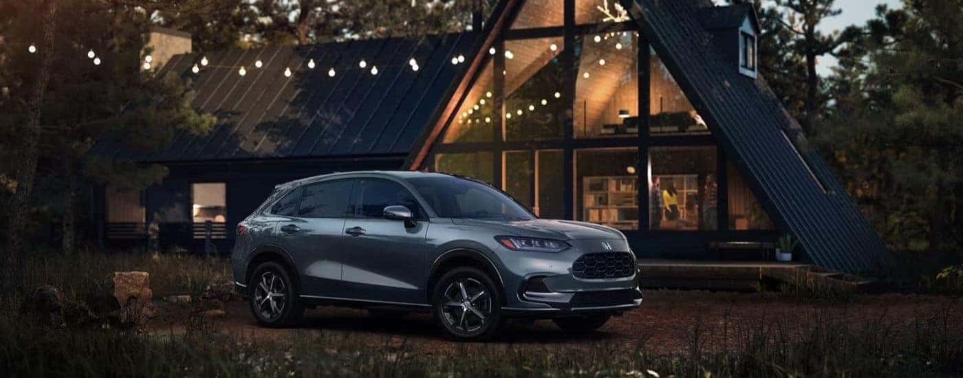 A used silver 2023 Honda HR-V EX-L parked outside a cabin