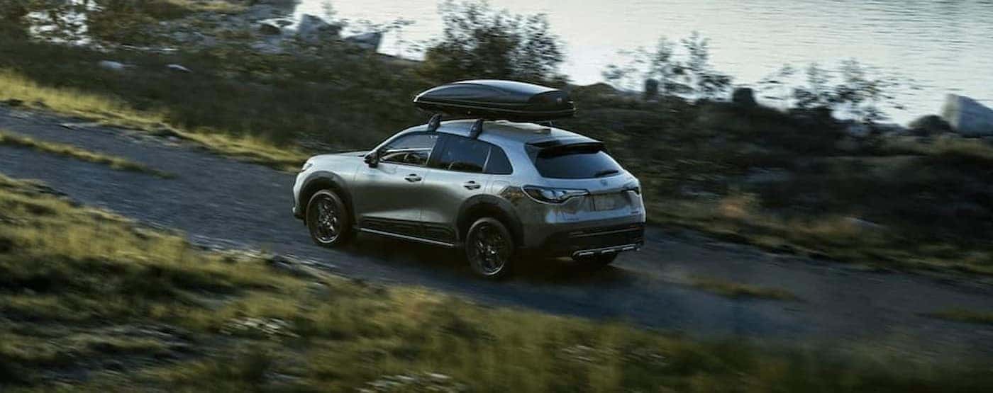 A silver 2023 Honda HR-V driving near water.
