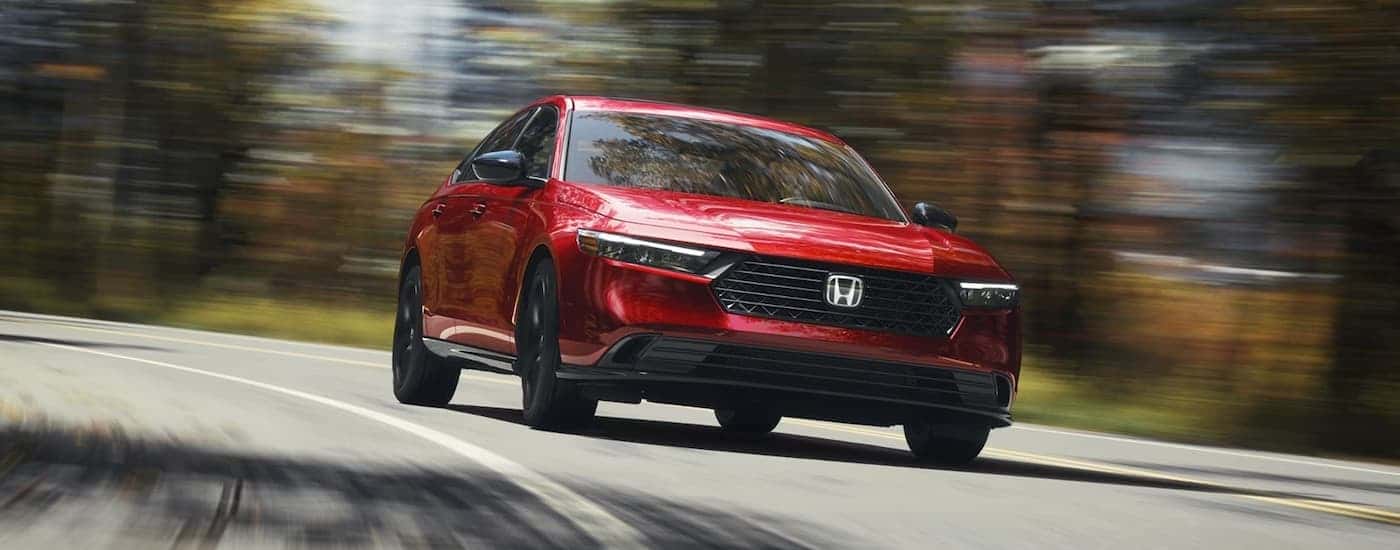 A red 2026 Honda Accord driving down a road