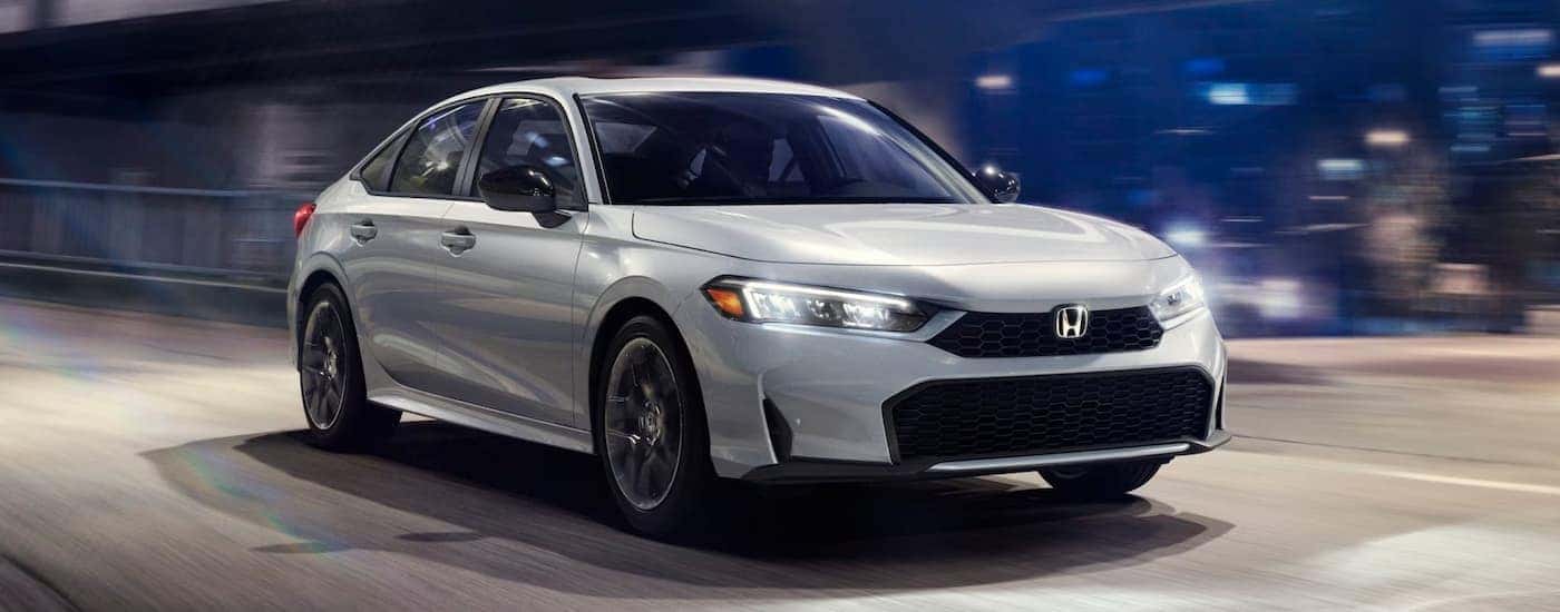 A silver 2026 Honda Civic driving on a city street