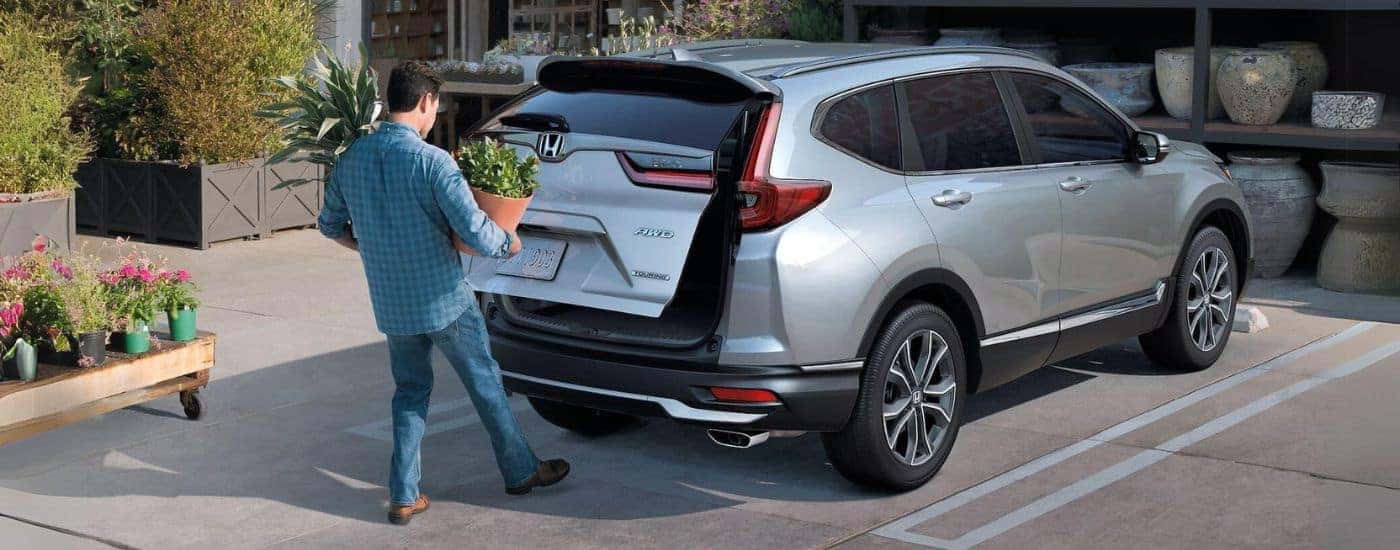 A silver 2021 Honda CR-V Touring parked with person using rear lift gate.