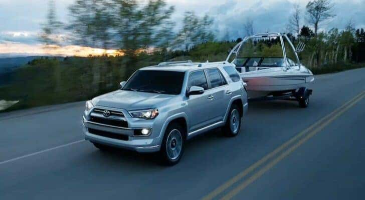 A silver 2023 Toyota 4Runner is shown towing a boat after visiting a Toyota dealer near Dunwood.