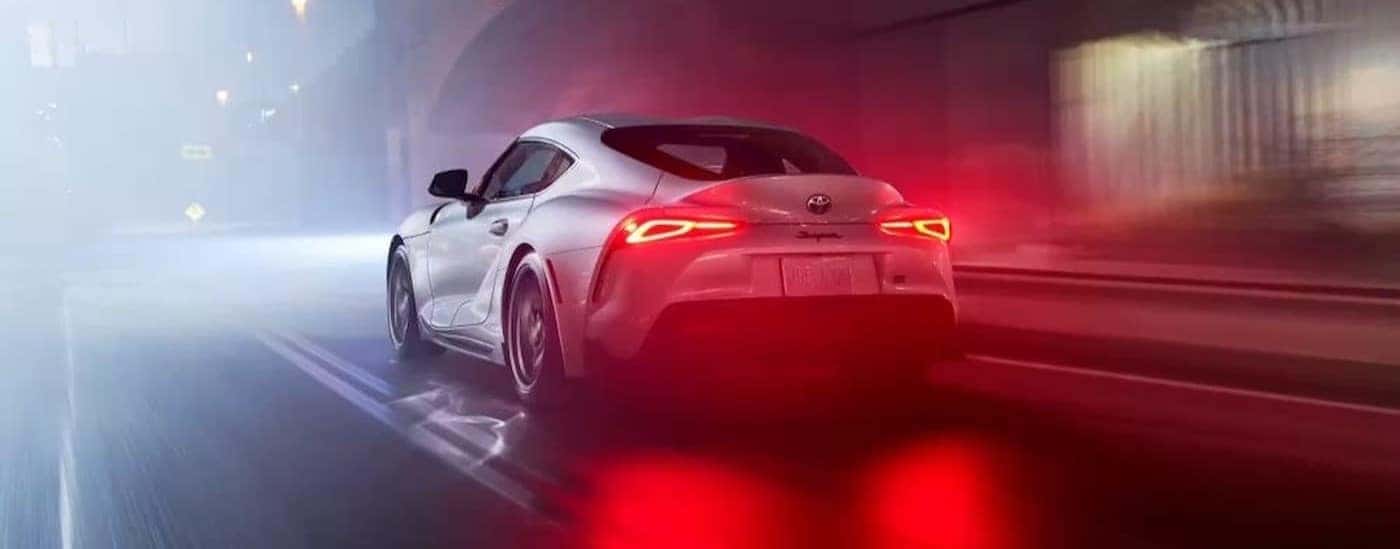 A white 2023 Toyota GR Supra is shown driving at night.