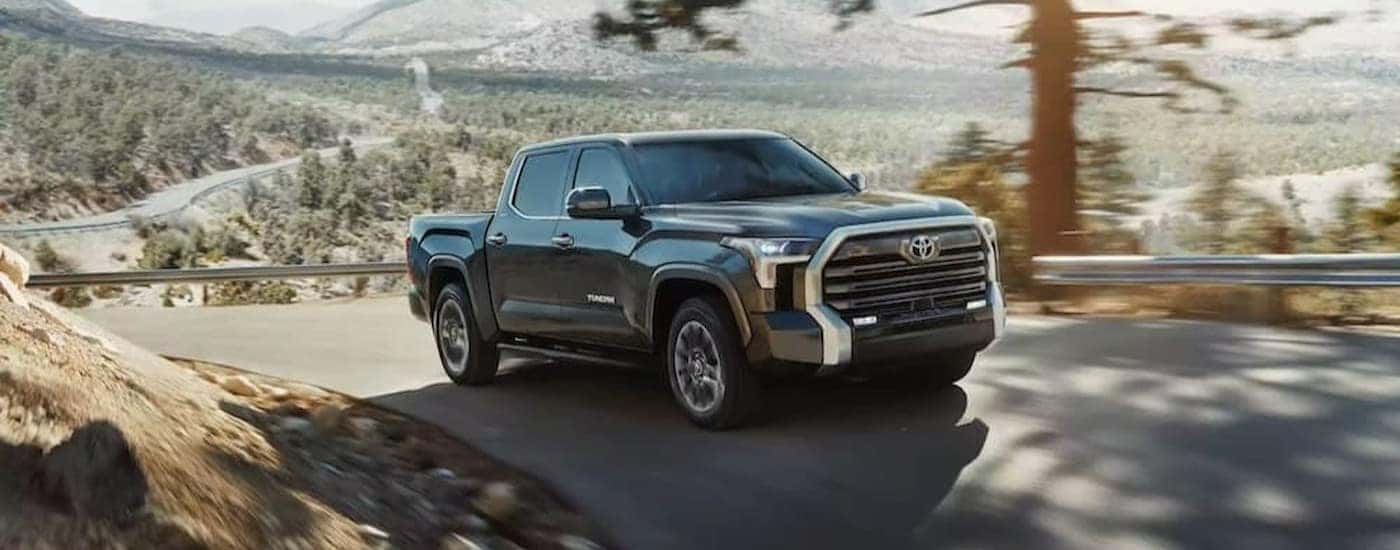 A gray 2023 Toyota Tundra is shown driving on a hill.