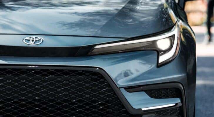 Close-up of the grille and headlight on a blue 2024 Toyota Corolla XSE at a Toyota dealer near Acworth.