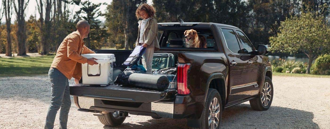 A family loading camping gear into the bed of a 2024 Toyota Tundra.