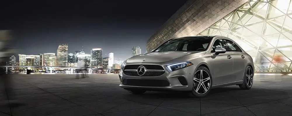 Silver 2021 A-Class parked in front of a city skyline at night