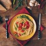 Italian pasta dish on a plate surrounded by ingredients