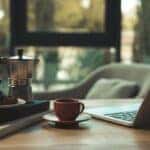 Table set up with coffee, food, and a laptop at a coffee shop