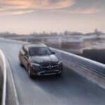Black 2026 Mercedes-Benz GLC 300 SUV driving across a bridge
