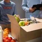 Volunteers packing a box of food