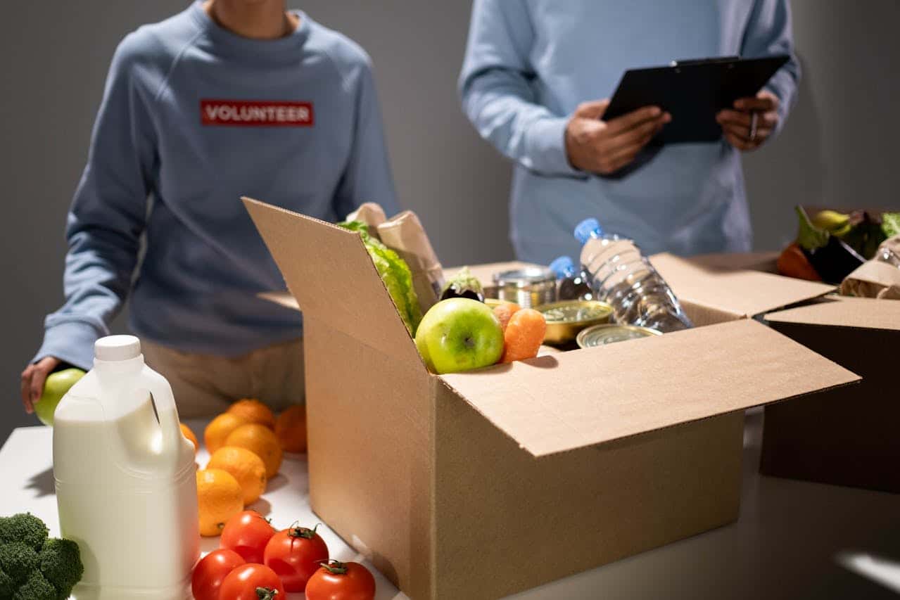 Volunteers packing a box of food