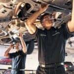 Mercedes-Benz service technicians working underneath a vehicle