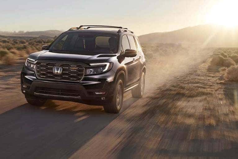 Black 2022 Honda Passport driving in the desert at sunrise