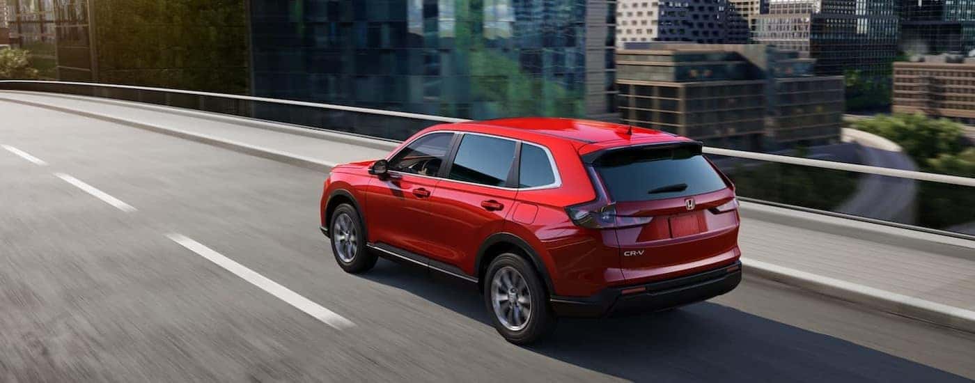 A red 2024 Honda CR-V is shown driving to a Honda dealer near Euless.