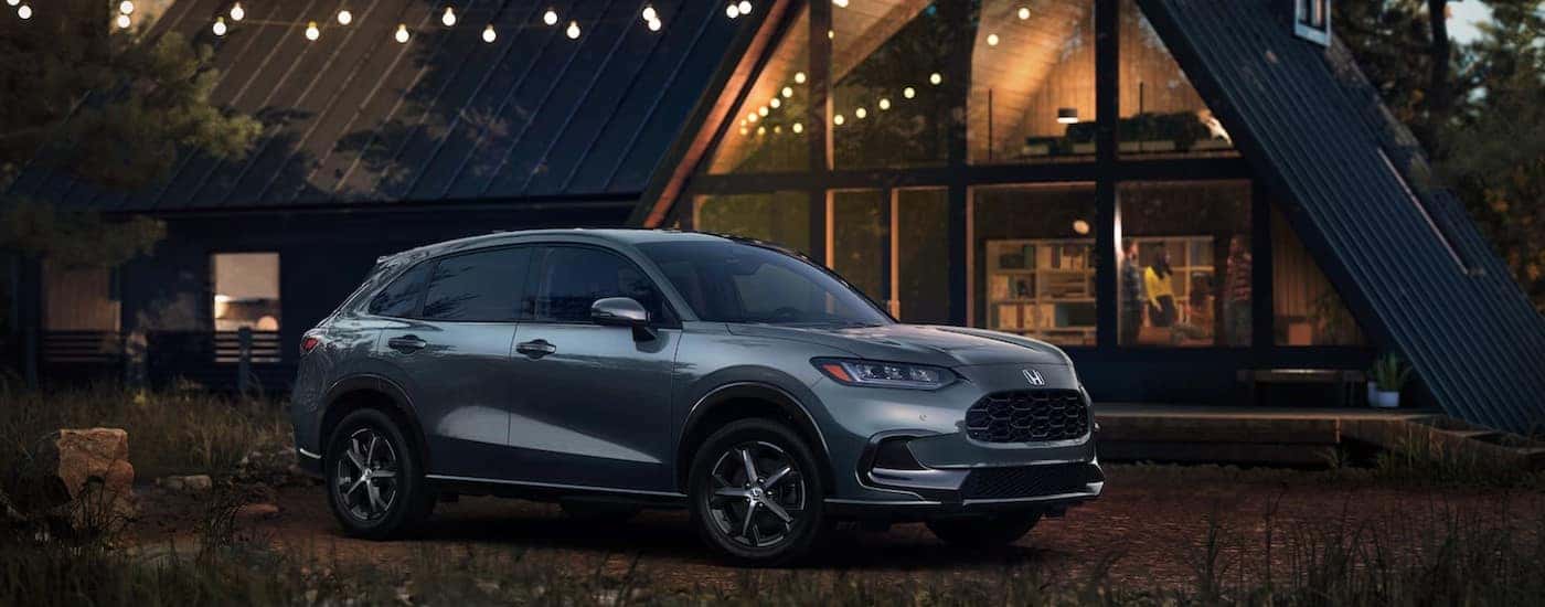 A silver 2024 Honda HR-V EX-L is shown parked near a cabin.