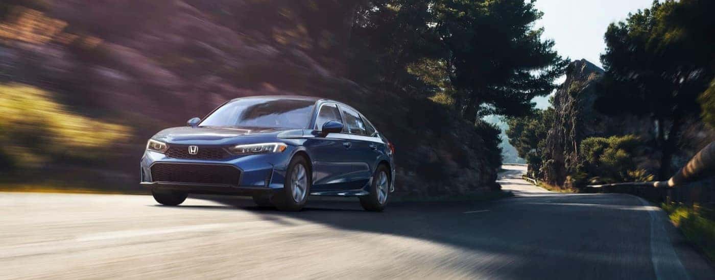 A blue 2025 Honda Civic LX is shown driving on a road.
