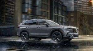 A gray 2024 Honda CR-V Sport Touring Hybrid is shown driving to view a CR-V for sale near Fort Worth.