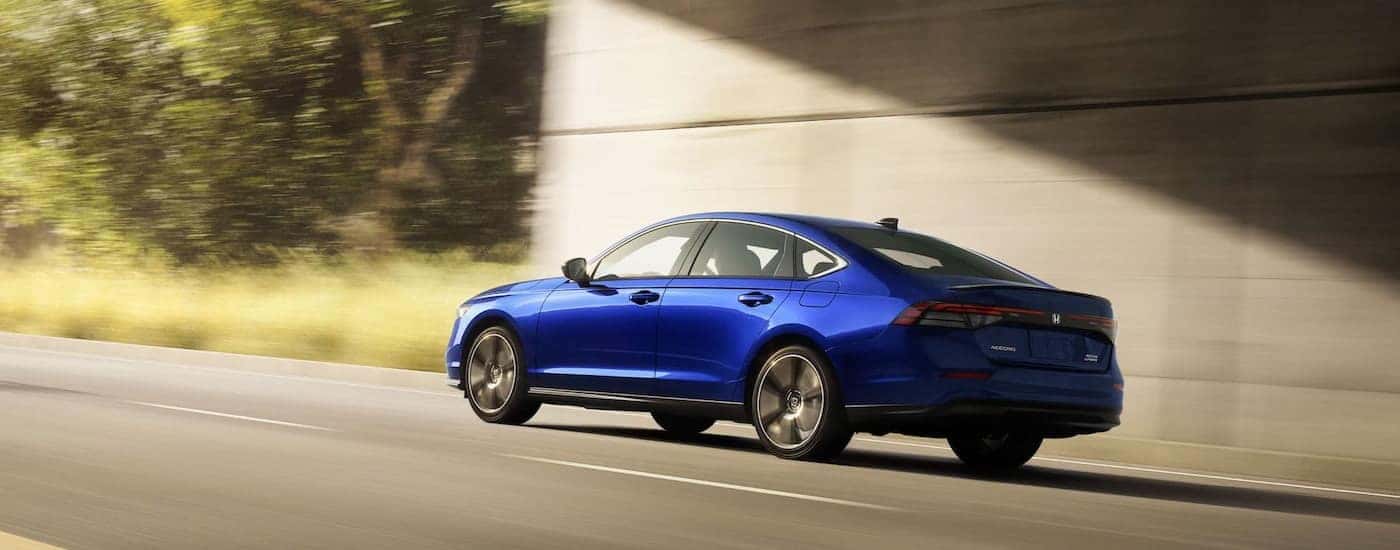 A blue 2024 Honda Accord is shown from the rear at a angle.