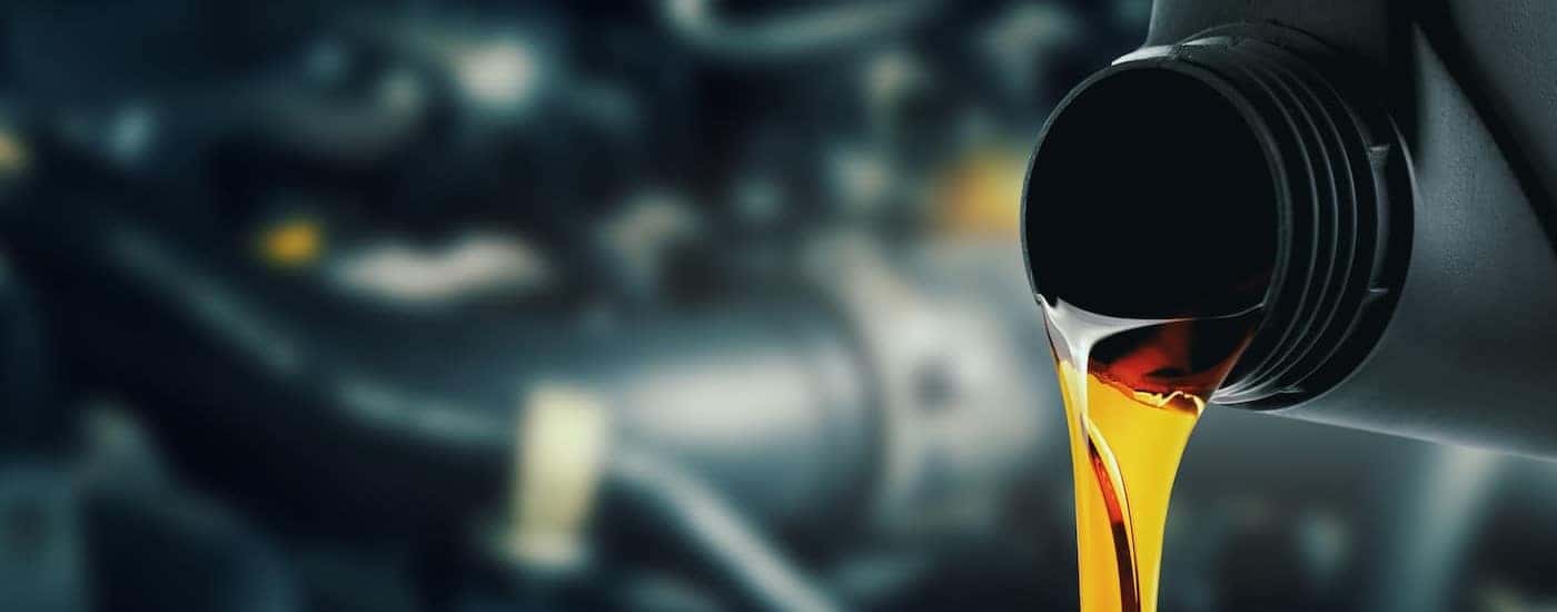 Oil is shown being poured out of a black container.