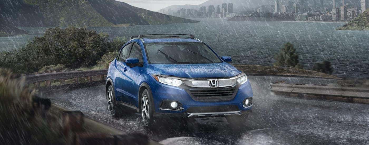A blue 2022 Honda HR-V EX-L driving down a winding road.