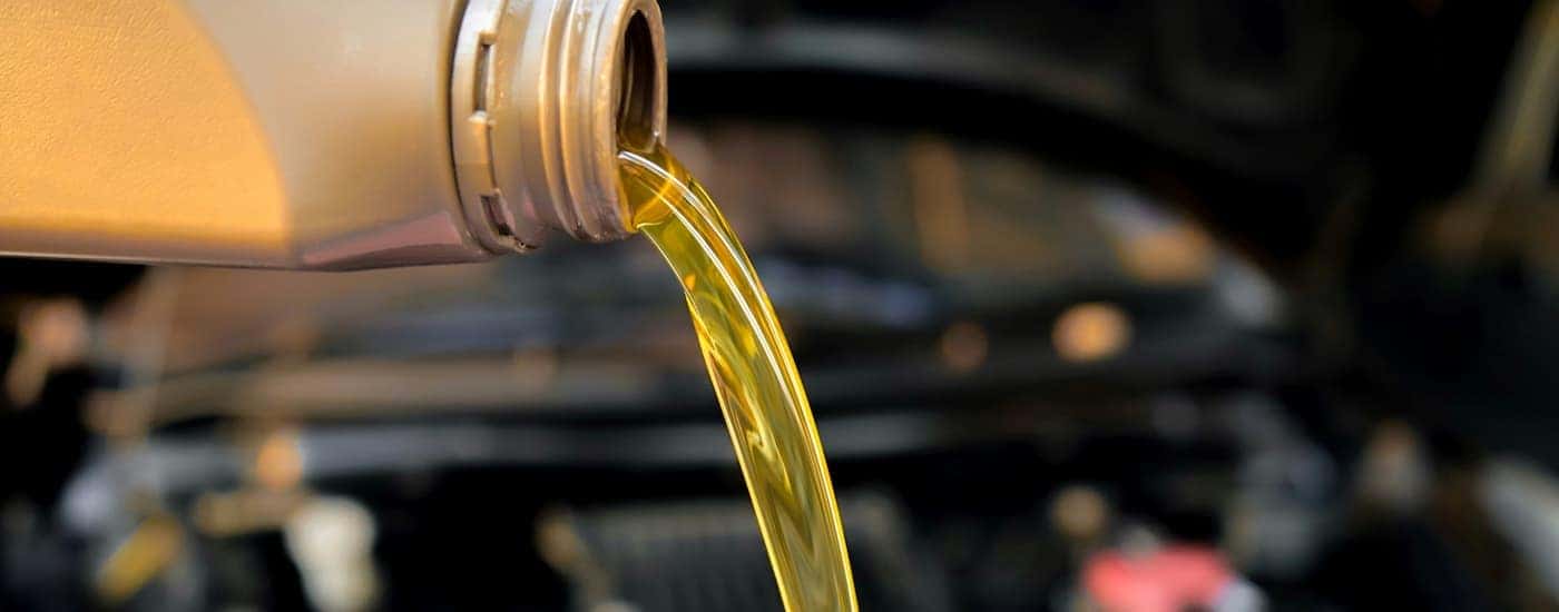 A can of oil being poured into an engine.
