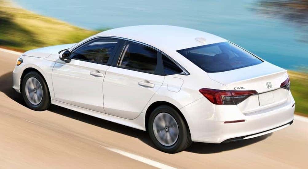 A white 2025 Honda Civic LX driving on a highway.