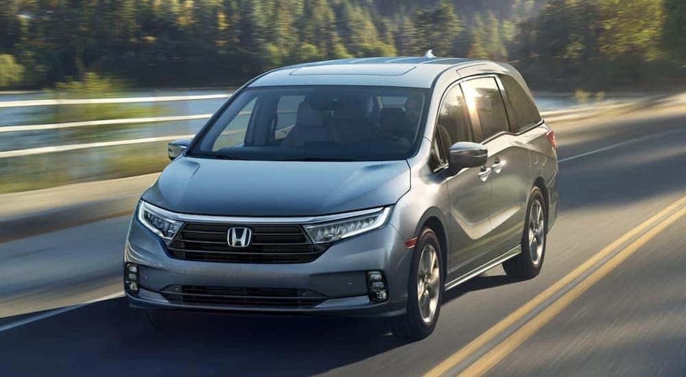 A silver 2025 Honda Odyssey Elite driving on a highway.