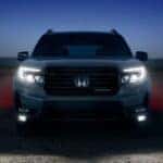 A silver 2025 Honda Passport for sale is parked at night.