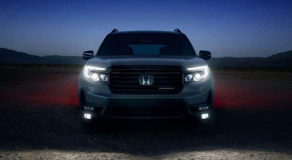 A silver 2025 Honda Passport for sale is parked at night.