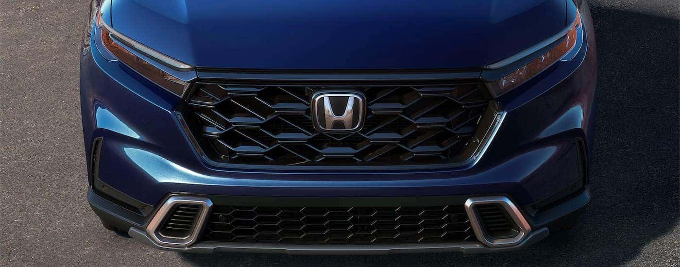 A close-up of the front end is shown on a blue 2024 Honda CR-V for sale.