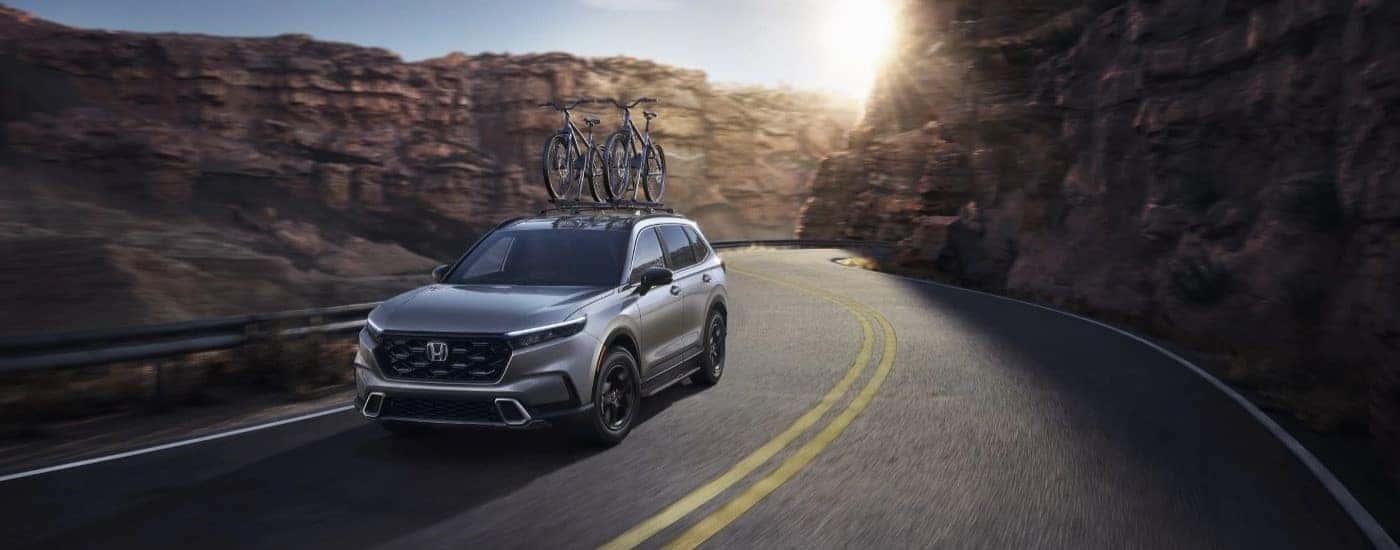 A silver 2023 Honda CR-V for sale in North Richland Hills is shown driving on a highway.