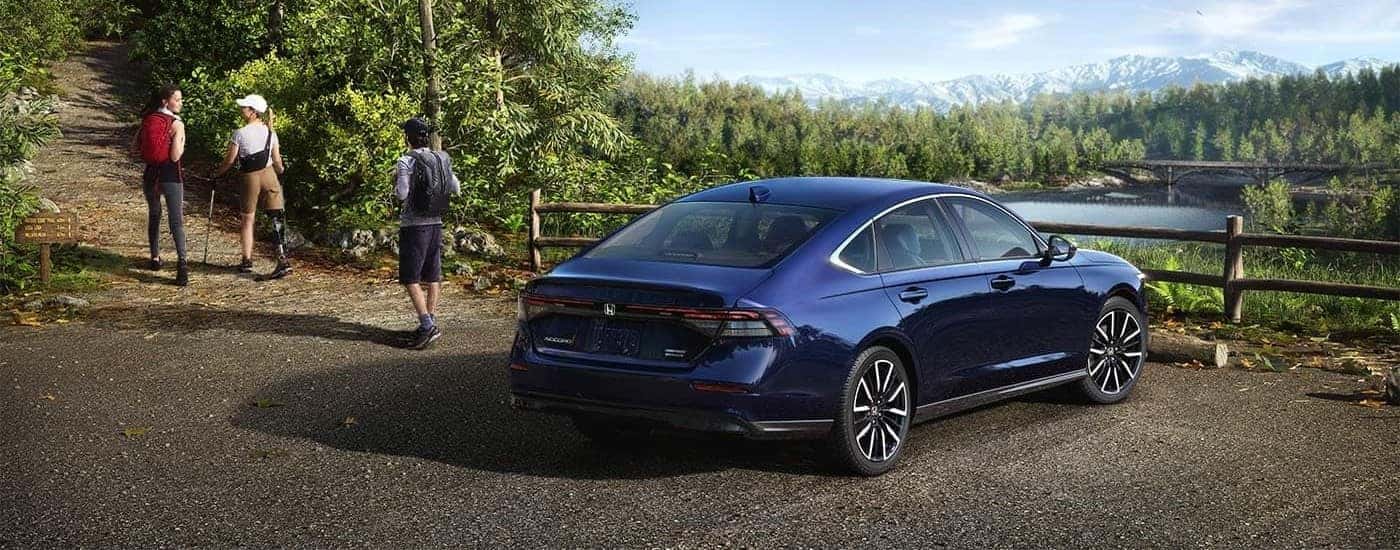 A blue 2024 Honda Accord Touring is shown parked near a river.