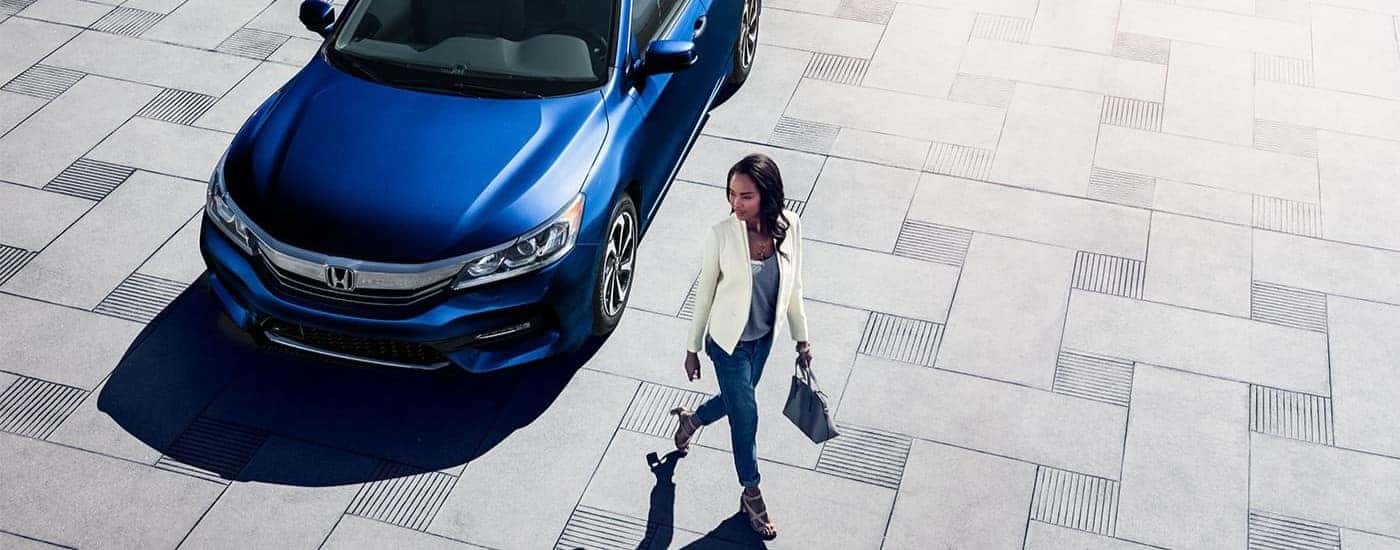 A person walking past a blue 2017 Honda Accord for sale in north Richland Hills.