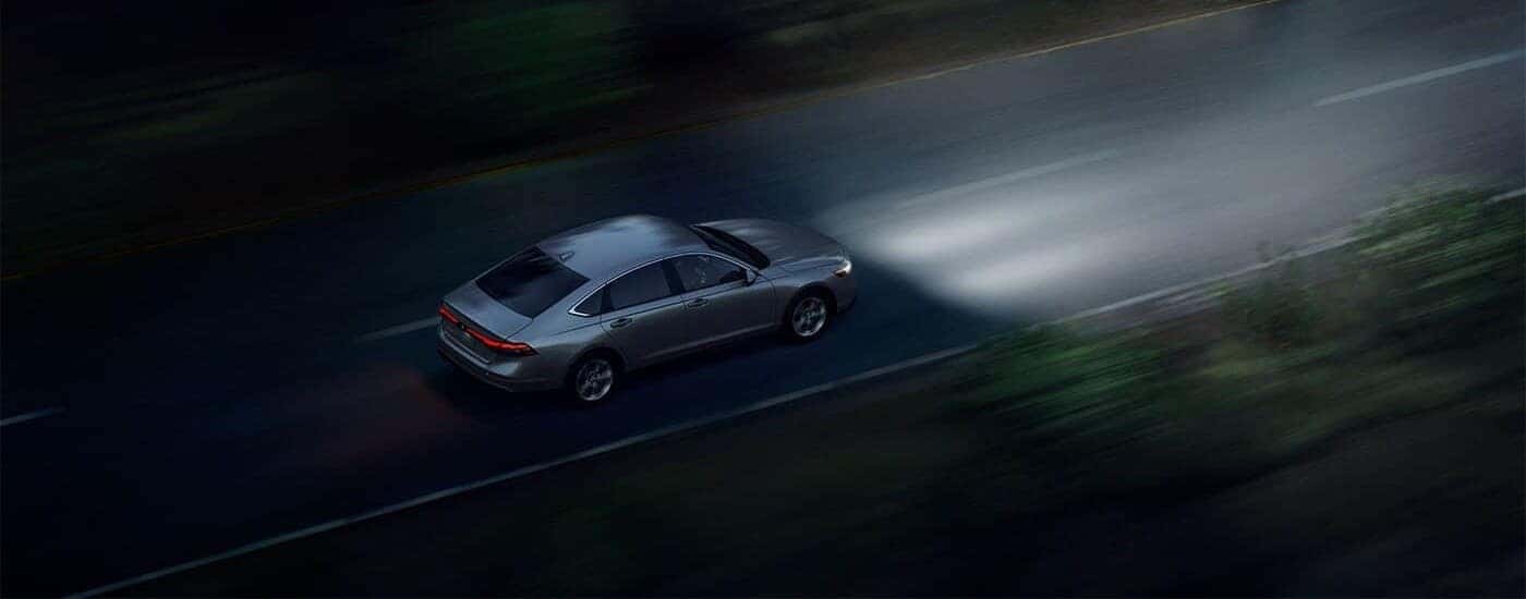 High angle view of a grey 2024 Honda Accord LX driving at night.
