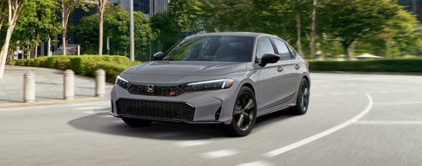 A gray 2025 Honda Civic Si is shown driving to a Honda dealer near Keller.