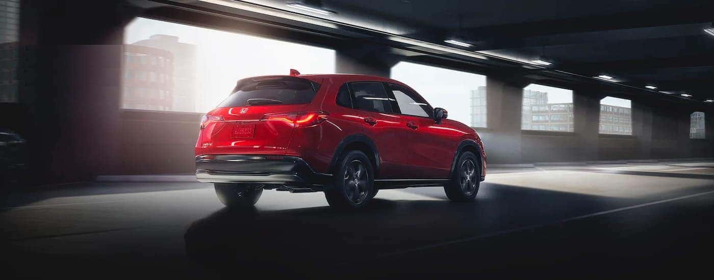 A red 2025 Honda HR-V EX-L driving to view a Honda HR-V for sale near Grapevine.