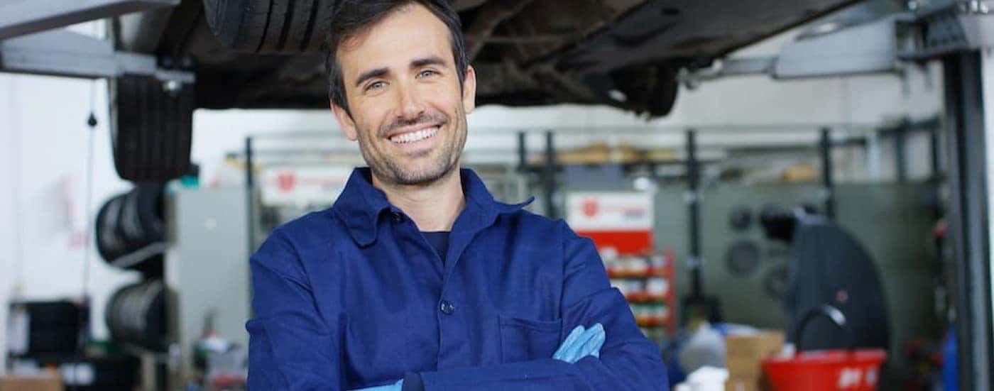 A technician smiling in a garage.