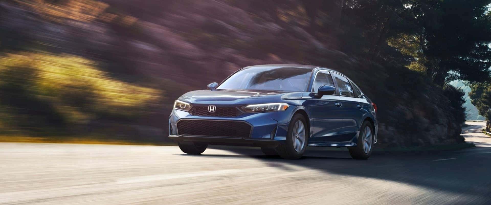 Blue 2026 Honda Civic LX for sale near Irving driving down a road.