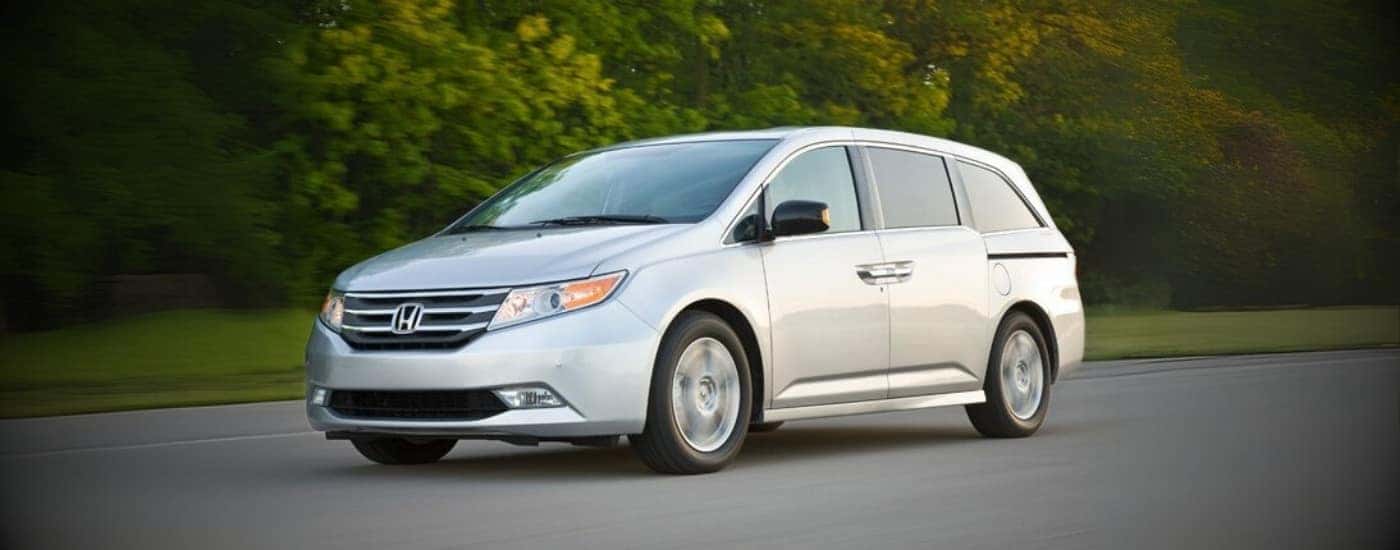 A silver 2012 Honda Odyssey driving on a highway.