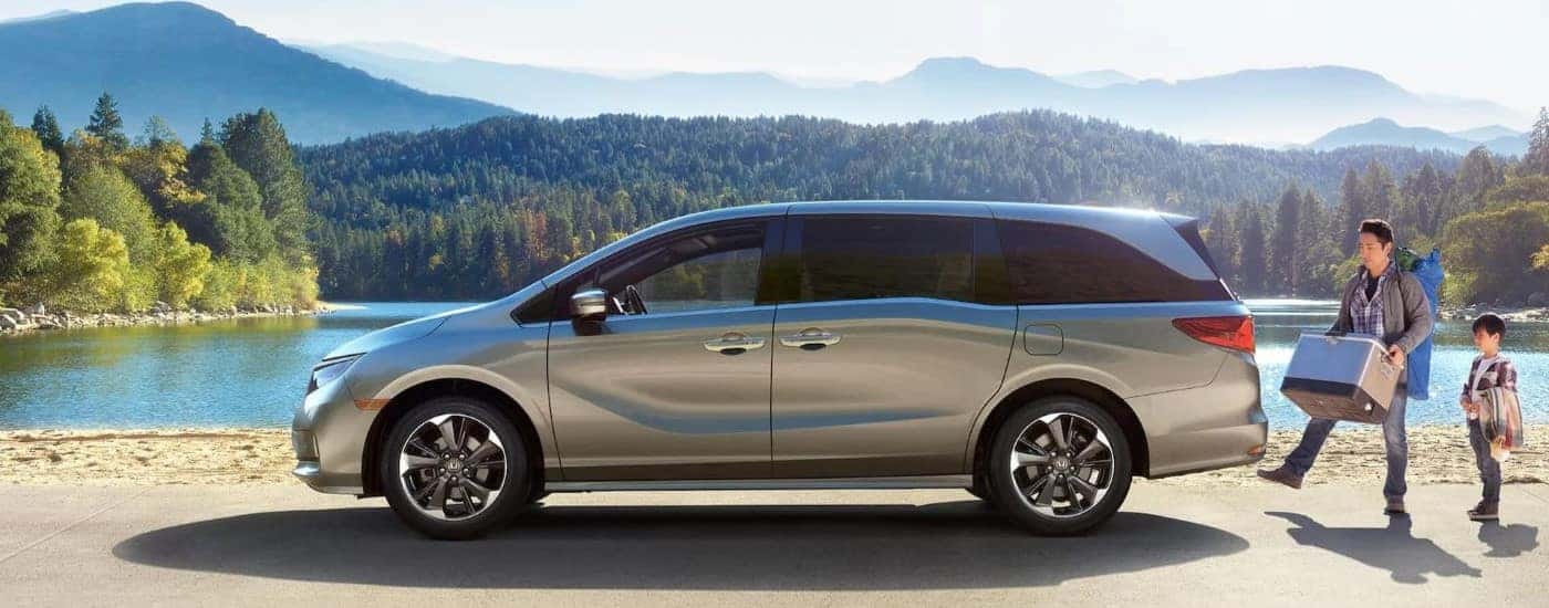 A silver 2023 Honda Odyssey parked near a lake
