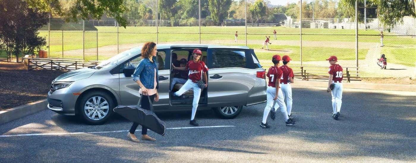 A family going to baseball practice in a silver 2024 Honda Odyssey Elite