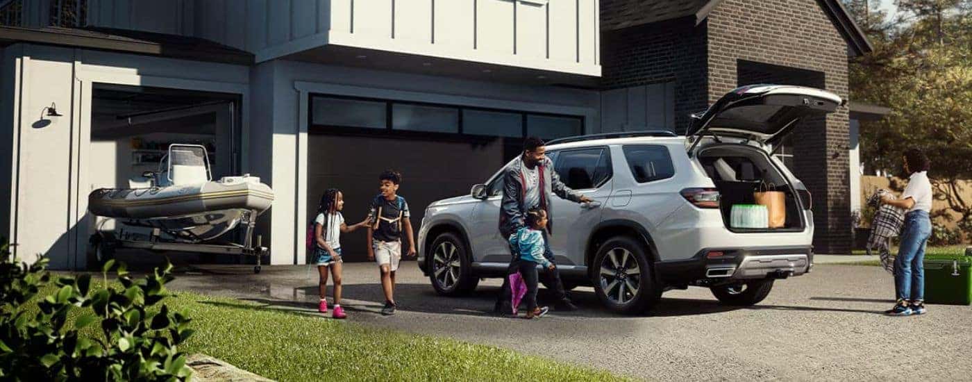 A white 2023 Honda Pilot Touring parked on a driveway.