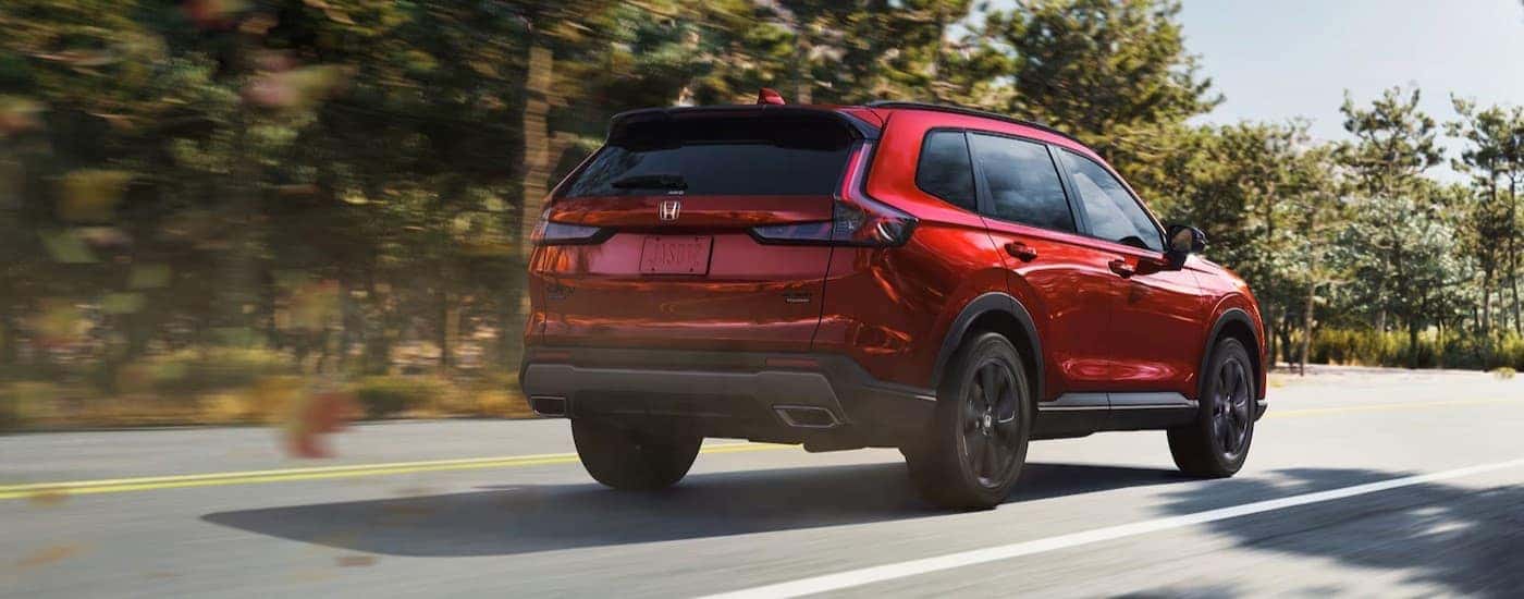 A red 2026 Honda CR-V driving to a Honda dealer near Newark.
