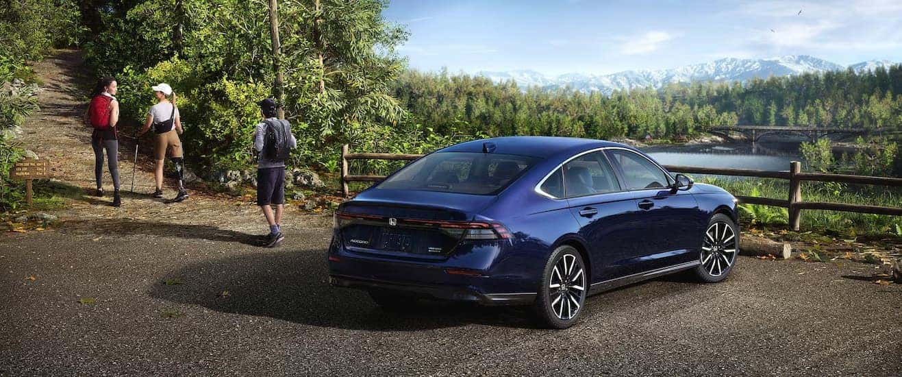 A blue 2025 Honda Accord parked off-road at a trail entrance