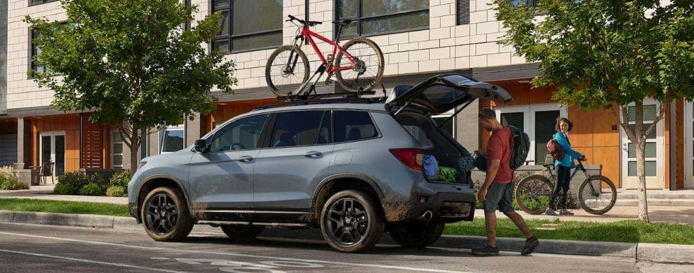 A gray 2024 Honda Passport parked near a house after viewing a used Honda for sale in North Richland Hills.