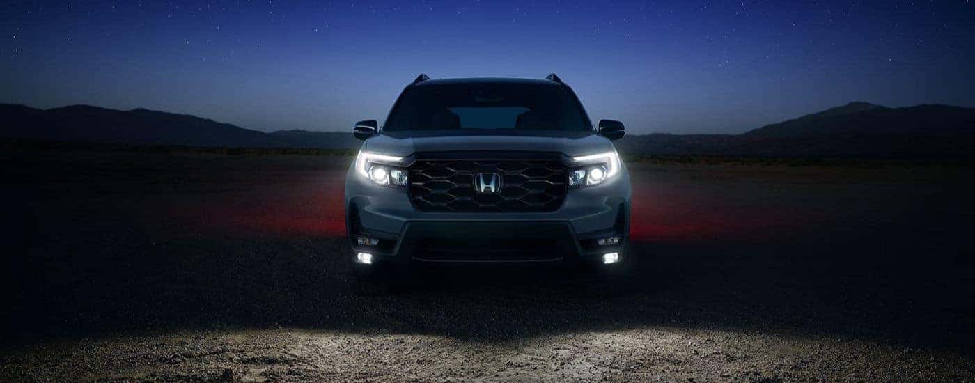 A silver 2023 Honda Passport Elite for sale near Colleyville parked off-road at night
