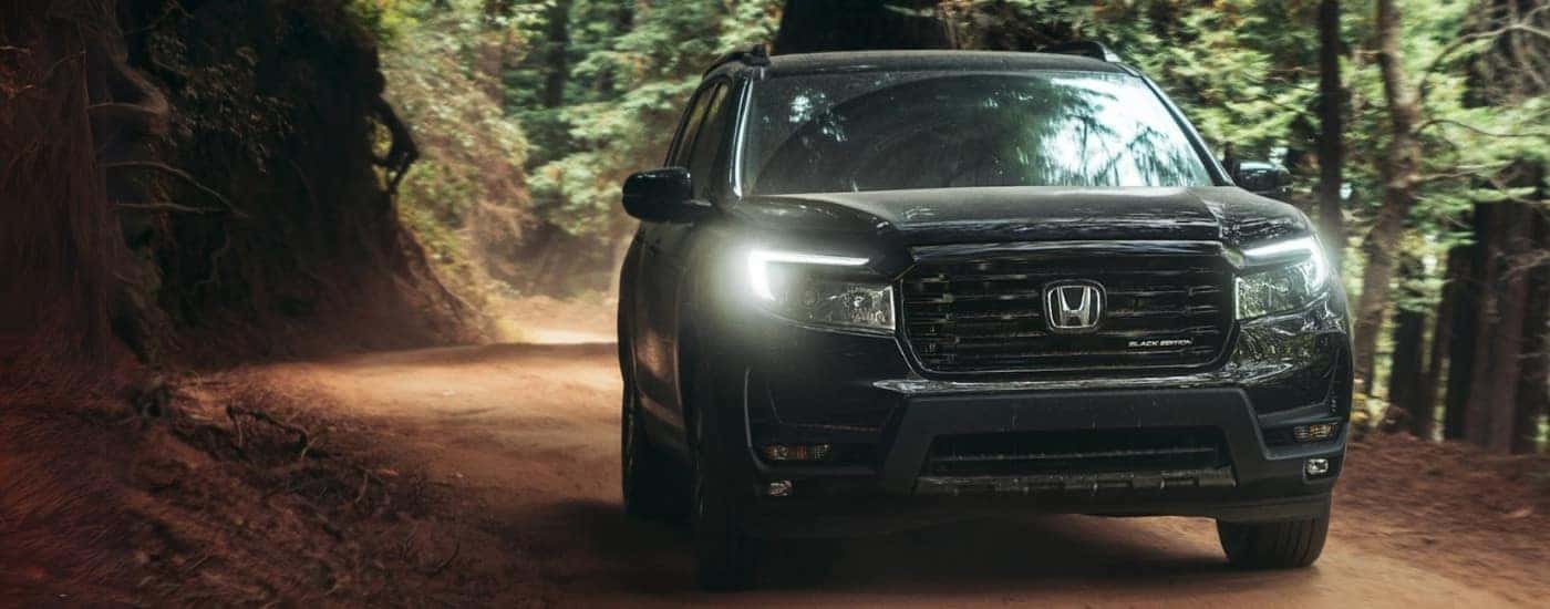 A black 2025 Honda Passport Black Edition off-roading on a dirt trail